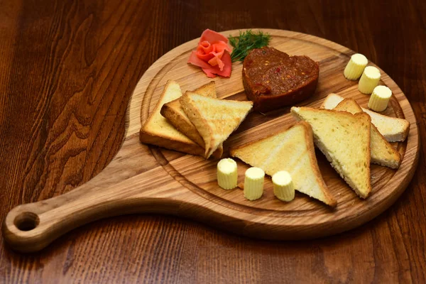 Tosty i masło serwowane na drewnianą deską do krojenia. Chrupiące tosty chleb. Dla miłośników skorupa — Zdjęcie stockowe