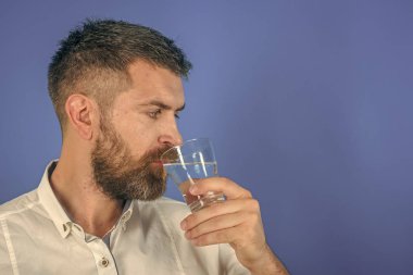 Uzun sakallı adam tutun su cam üzerinde mavi arka plan.