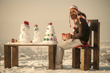 Sandalyede oturan şapkalı adam