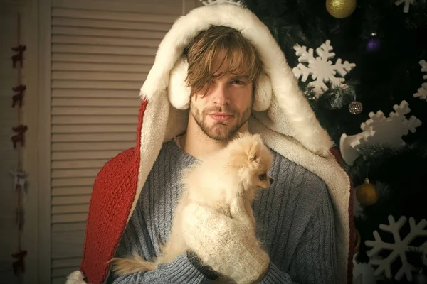 santa claus man with pet at tree.