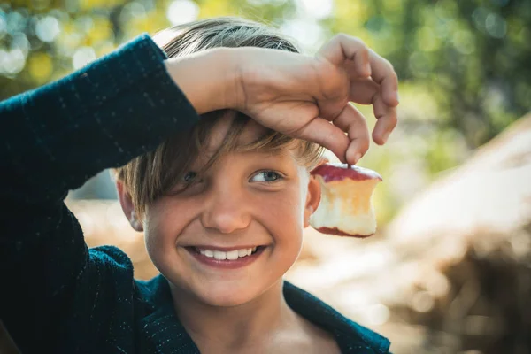 Αστεία μικρό ευτυχισμένο αγόρι τρώει σε ένα αγρόκτημα. Παιδί απολαμβάνει φθινοπωρινή σεζόν και γελώντας. Ευτυχισμένη παιδική ηλικία, αντίληψη του τρόπου ζωής. Αστεία κουζίνα. — Φωτογραφία Αρχείου