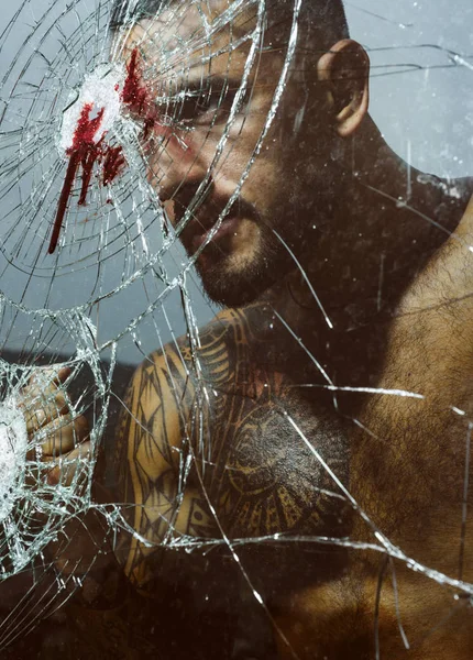 Starker wütender Mann in der Nähe der Glasscherben nach dem Unfall. Kraft und Wut Konzept. Blut. — Stockfoto