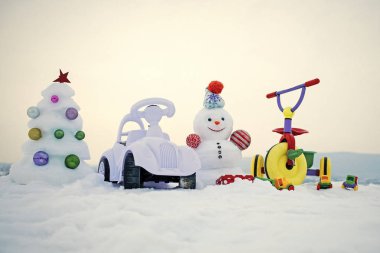 Üç tekerlekli bisiklet ve oyuncak araba karlı zemin üzerine