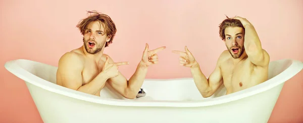 Hombres, gemelos sorprendidos señalándose los dedos en el baño —  Fotos de Stock