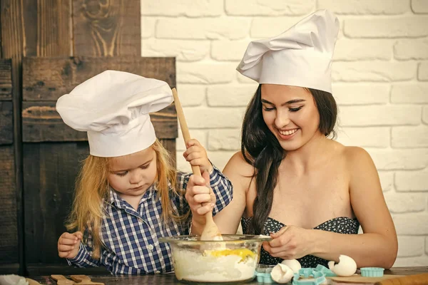 Chef şapka kaşık ile kadın ve çocuk çocuk — Stok fotoğraf