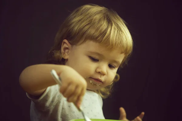 Маленький мальчик ест кашу — стоковое фото
