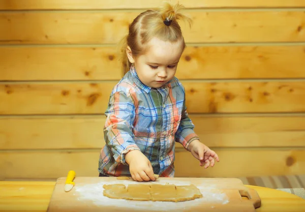 Cute child in checkered shirt cooking with dough and flour — Stock Photo, Image