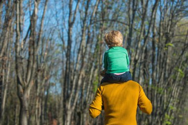 Baba Çocuk sırtlama Park vererek omuz küçük oğlu dur. Atçılık oynayalım. Beni yukarı götür