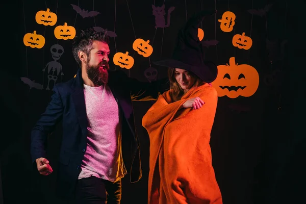 黒い背景に衣装のハロウィーンの家族。ハロウィーン。男と女の家で楽しい時を過します。パーティーやハロウィーンのお祭り。カーニバルの衣装を着ている人. — ストック写真