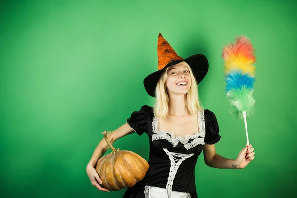 Verbaasd huishoudster vrouw met Pumpkin spel en poseren. Halloween brede banner met Sexy meisje huishoudster. Kostuums en heks hoeden. — Stockfoto