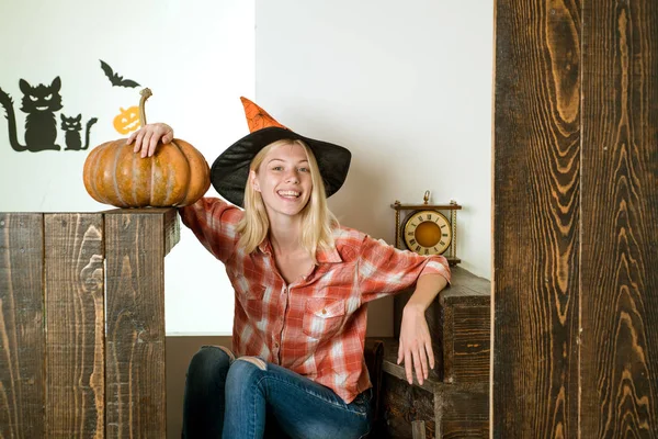 Une femme souriante. Femme posant avec de la citrouille. Belle jeune femme surprise en chapeau de sorcières et costume tenant citrouille. Des gens heureux . — Photo