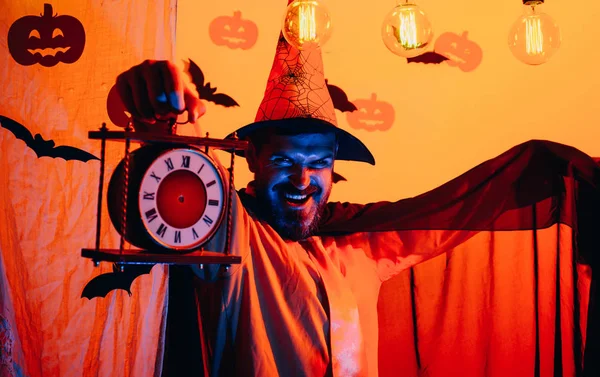 E 'ora dell'orrore. 31 ottobre. Le migliori idee per Halloween. Un uomo barbuto con un orologio emette un incantesimo. Faccia spaventosa uomo . — Foto Stock