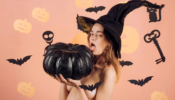 Strega di Halloween con cappello magico. Bella giovane donna sorpresa in cappello streghe e costume tenendo zucca. Glamour moda sexy vampiro signora . — Foto Stock