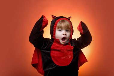 Mutlu çocuklar halloween. Komik çocuk turuncu zemin üzerine karnaval kostümleri. Korkunç bir yüz. Korku yüzler. Komik surat. Amerika'da çocuk Cadılar Bayramı kutlamak.