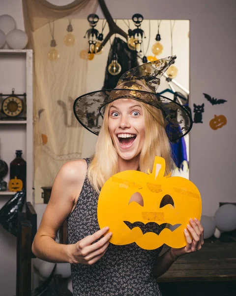 Belle femme surprise en chapeau et costume de sorcières. Femme posant avec de la citrouille. Sorcière d'Halloween. Belle jeune femme surprise en chapeau de sorcières et costume tenant citrouille . — Photo