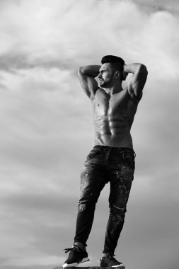 Mavi gökyüzü üzerinde kas vücut maço adam