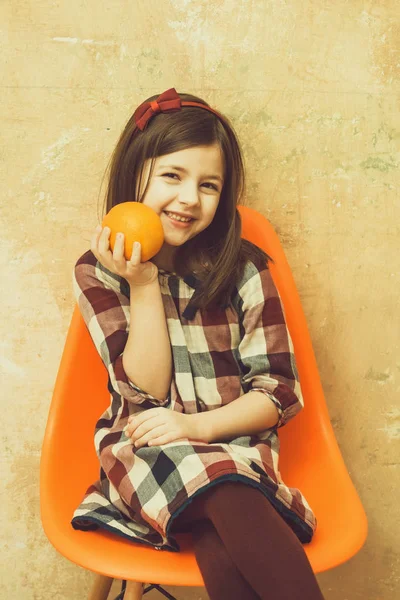 Šťastná dívka s roztomilý úsměv a v ruce usmívat pomeranč — Stock fotografie