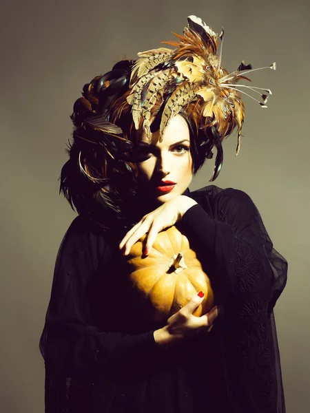 Красива жінка в капелюсі тримає гарбуз на Хеллоуїн — стокове фото