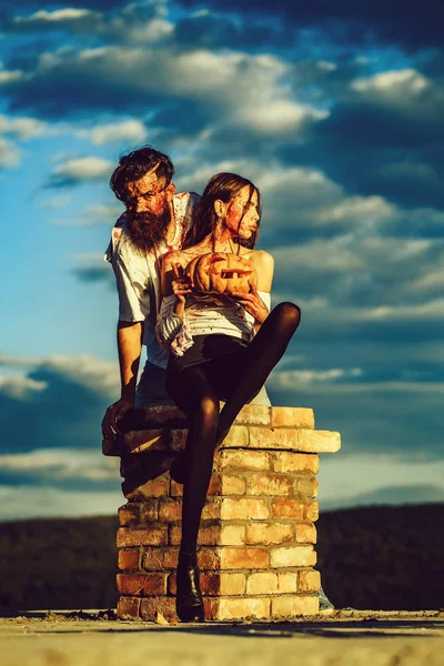 Halloween zombie paar bebaarde man en meisje houdt pompoen — Stockfoto