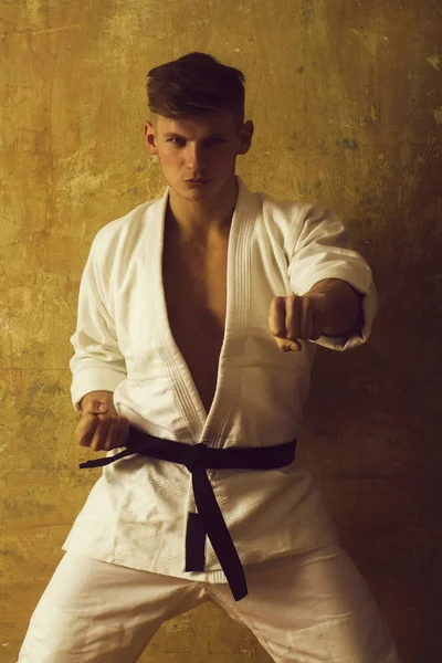 Karatetraining in weißem Kimono auf beigem Hintergrund, Sport — Stockfoto