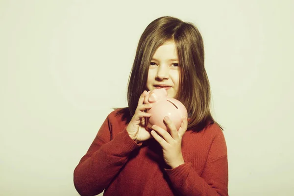Копилка в руках маленькой девочки улыбающейся — стоковое фото