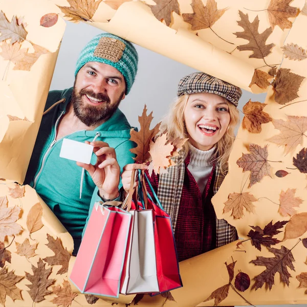 Funny couple are getting ready for autumn sale. Colorful autumn and dry leaf. Romantic couple wearing pullover on autumn leaves background. — Stock Photo, Image