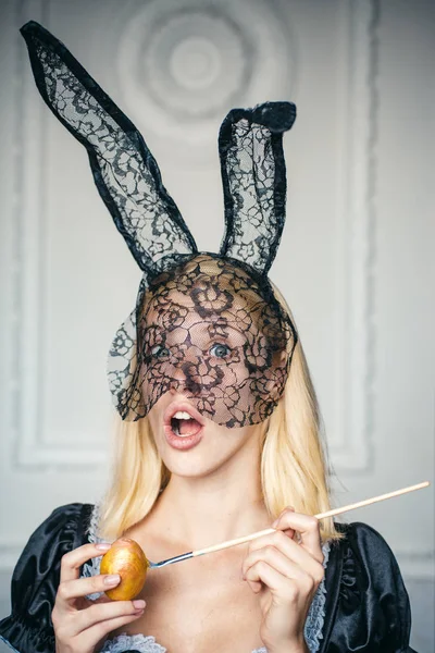 Aantrekkelijke jonge vrouw bunny oren dragen. Close-up portret. Gelukkig jonge vrouw schilderij eieren. Blond meisje dragen bunny oren en met paaseieren. Cute bunny. — Stockfoto