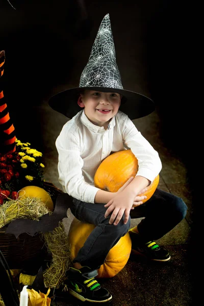 Halloween kind in heks hoed met gele pompoen — Stockfoto