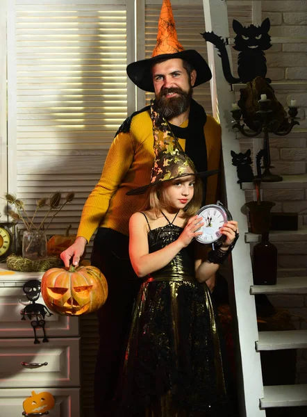 Маленька дівчинка з годинником чекає на вечірку на Хелловін. Маленька дівчинка з батьком влаштовує вечірку на костюмах. Нехай удача буде вашою на Хеллоуїн. Насолоджуйтесь відпочинком разом — стокове фото
