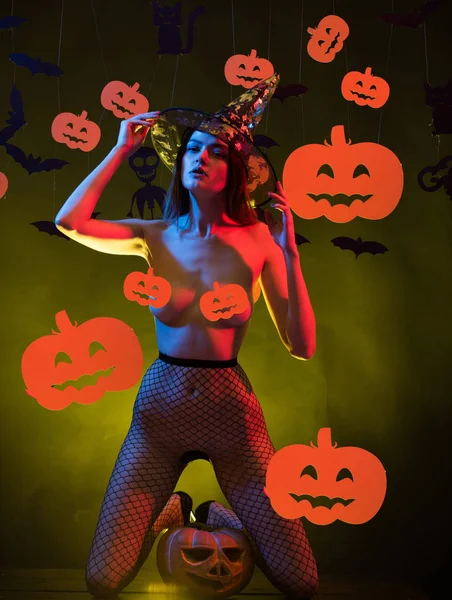 Halloween naakt heks in zwarte hoed. Sexy vrouw poseren met pompoen. Mooie erotische vrouw in heksen hoed poseren naakt. Sexy heks vampier concept. — Stockfoto