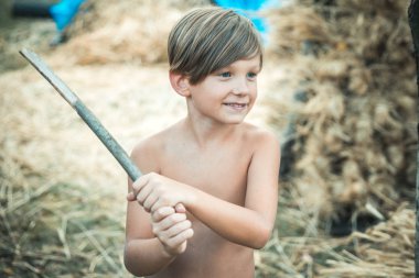 Çocukluk gruptaki. Köy zamanla. Çocuk ben sonbahar güneşli gün için hazırlanıyor. Çocuk bir sopa tarafından korunmaktadır.