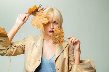 Mutlu genç kadın için sonbahar güneşli gün hazırlıyoruz. Güzel kız boşaltmak için tahta arka plan ile. Bir mevsimlik giysiler whith altın varak çekici genç kadın. Güzel seksi sarışın.