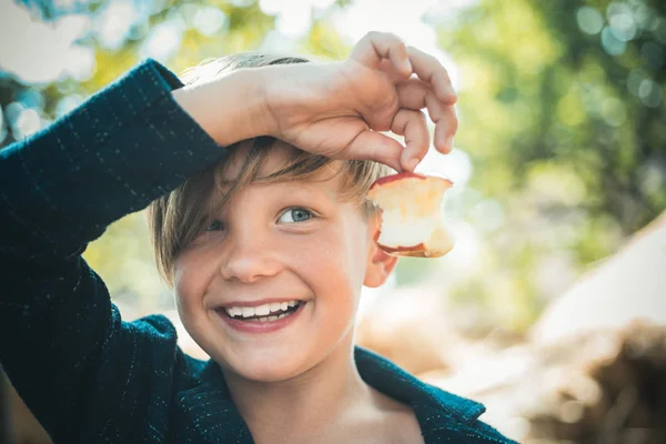 Αγόρι στο καπέλο κρατώντας apple και ψέματα στο σανό. Χαριτωμένο μικρό παιδί αγόρι εκμετάλλευση αγρόκτημα χωριό φόντο φύλλο χρυσού. Βιταμίνες το φθινόπωρο. Χαριτωμένο μικρό αγόρι. — Φωτογραφία Αρχείου