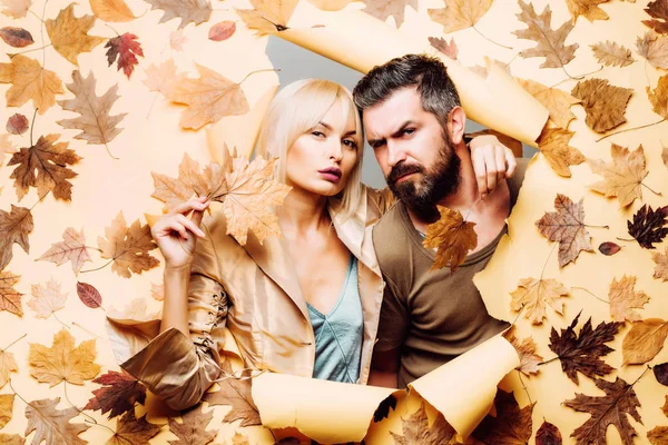 Funny couple are getting ready for autumn sale. Couple in Love wearing in fashionable seasonal clothes having Autumnal mood. Beautiful tender couple advertise your product and services. Autumn people.