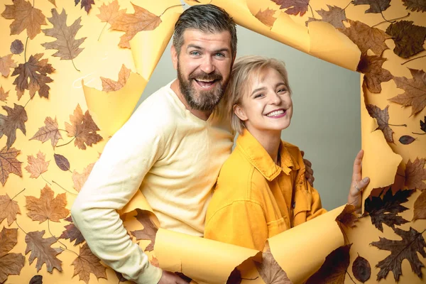 Romantikus pár fárasztó a pulóver a őszi levelek háttér. Gyönyörű pályázati pár hirdet-a termékek és szolgáltatások. Vicces pár készül az őszi eladó. Őszi koncepció. — Stock Fotó