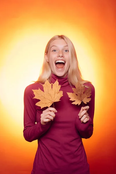 Boldog fiatal nő készül az őszi napsütésben. Tartó arany levél őszi női. Lombhullás. Boldog ember, szórakozik. Meglepett asszony. — Stock Fotó