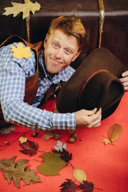 Zencefilli adam sonbahar satış günü için hazırlıyoruz. Sürpriz adam kameraya bakıyor. Turuncu yaprak zemin üzerine komik adam. Mutlu sonbahar insanlar kavramı.