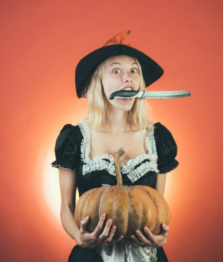 Siyah şapkalı Cadılar Bayramı Cadısı. Balkabağıyla poz veren kadın. Balkabağı kafalı Jack Lantern. Şeker mi şaka mı? Cadılar Bayramı kostümlü çekici bir manken kız. Korkunç yüzler.