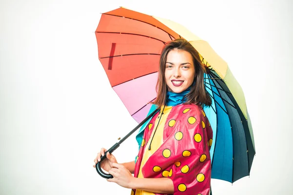 Regen en paraplu november concept. Geweldige mooie vrouw met regenboog-gekleurde paraplu geïsoleerd op een witte achtergrond. Portret van de mode van mooie sensuele vrouw. Herfst concept. — Stockfoto