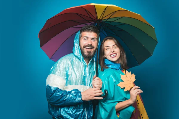 Surprised couple on autumn clothes discounts, man with beard and an attractive girl. Funny couple are getting ready for autumn sale. Happy couple in love wearing in autumn clothes on autumn rain day.