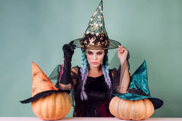 黒い帽子でハロウィンの魔女。女性がかぼちゃのポーズします。カボチャ頭のジャック ランタン。お菓子をくれないといたずらするよ。魔女の衣装でグラマー ファッションのセクシーな吸血鬼の女性. — ストック写真