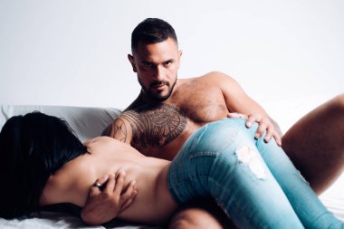 Seksi çift yatakta. Seks korumak ve cinsel yaşam. Samimi ilişki ve cinsel ilişki. Genç kadının bacakları kot moda. Gece parti - genç aşıklar. Emniyet seks konsepti.