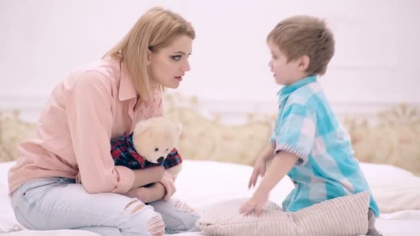 Mamá y el niño hablan en el dormitorio de la cama. concepto de comunicación familiar. Una familia feliz . — Vídeos de Stock