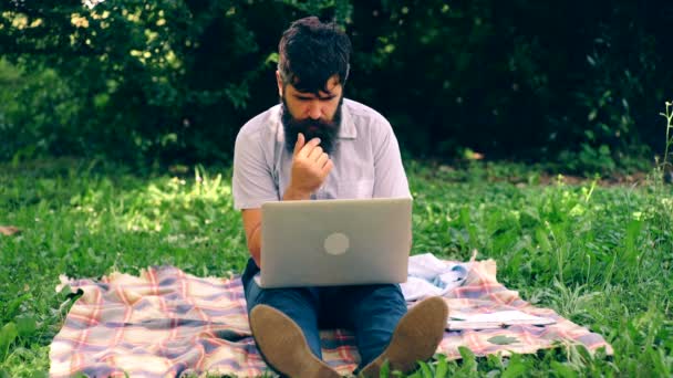 De bebaarde man met laptop in een park. — Stockvideo