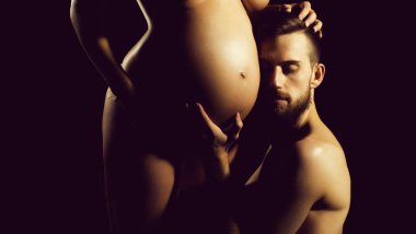 sakallı adam ve çok hamile kadın çıplak yuvarlak karın ile