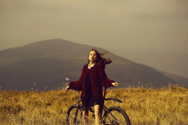 Chica con bicicleta en la montaña — Foto de Stock