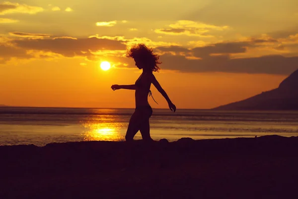 सूर्यास्त समुद्र तट में महिला सिल्हूट — स्टॉक फ़ोटो, इमेज