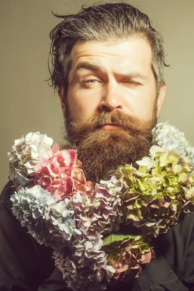 Homem barbudo com flores de hortênsia — Fotografia de Stock