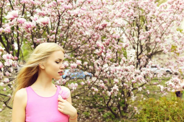 Vrouw houd magnolia bloem bloeiende boom, lentetuin — Stockfoto