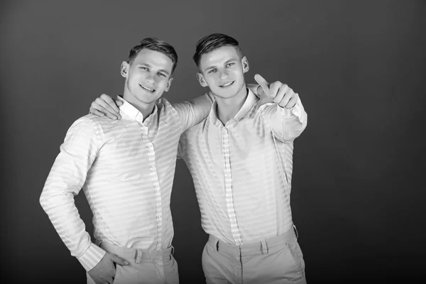 Два брати посміхаються і вказують пальцем — стокове фото